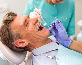 Older male patient laughing during dental examination