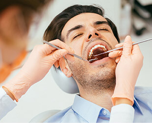 Man examined in dental chair