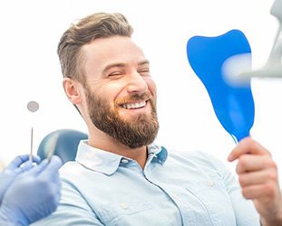 Man in dental chair looking at smile