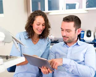 Dentist explaining how a root canal in Huntsville works