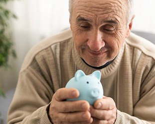 Man gently holding a blue piggy bank