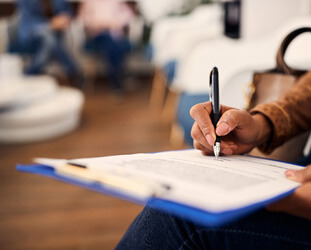 woman filling out dental insurance form in lobby