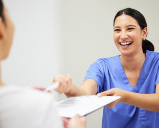 Receptionist helping patient with dental insurance in Huntsville 