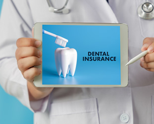 Dentist holding tablet that reads Dental Insurance 