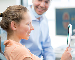 Young patient looking at smile in mirror