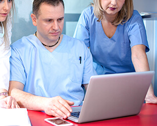 Dental team looking at laptop