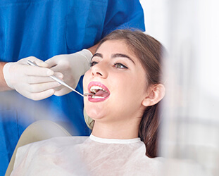 Young woman examined in dental chair