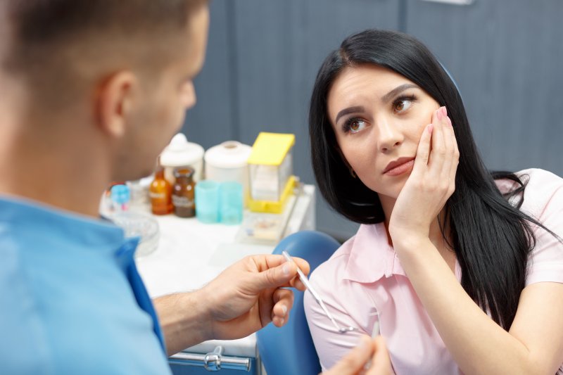 Dentist talking to patient with tooth pain