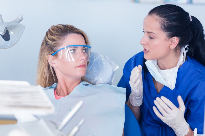 person speaking with dentist about what to avoid after apicoectomy