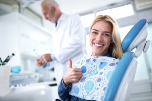 A patient smiling because she’s undergoing root canal therapy