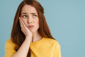 Woman holding her jaw in pain.